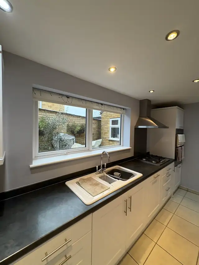 Kitchen with light grey walls and cream units