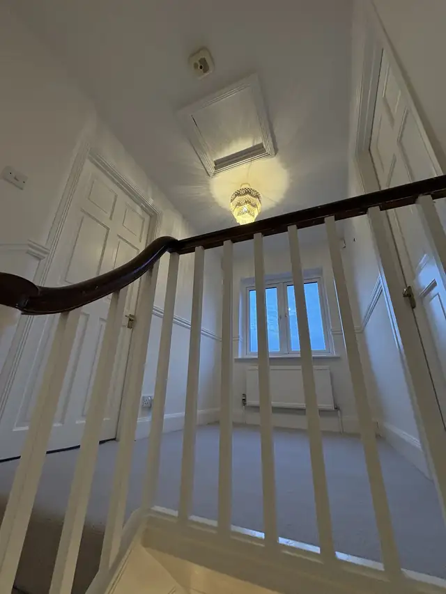 Landing with white spindles and a dark handrail